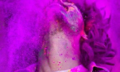 Young man covered in colored dye celebrating Holi festival in Jaipur, India.